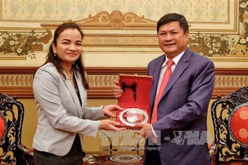 Bà Keo Sokpisey, Phó Đô trưởng Thủ đô Phnompenh tặng quà lưu niệm cho ông Huỳnh Cách Mạng, Phó Chủ tịch UBND Thành phố Hồ Chí Minh, nhân chuyến thăm thành phố. Ảnh: Thế Anh-TTXVN