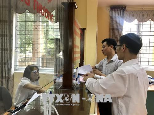 Ứng xử, giao tiếp với người dân đến làm thủ tục hành chính tại bộ phận một cửa UBND huyện Phúc Thọ. Ảnh: Đinh Thuận - TTXVN