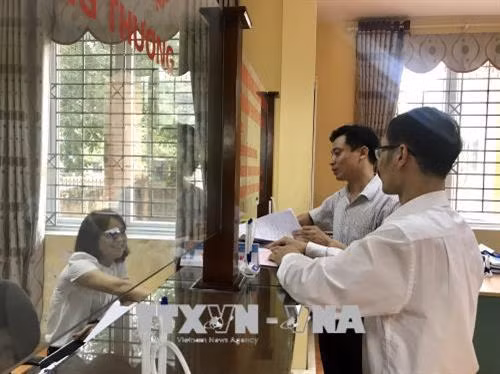 Ứng xử, giao tiếp với người dân đến làm thủ tục hành chính tại bộ phận một cửa UBND huyện Phúc Thọ. Ảnh: Đinh Thuận - TTXVN