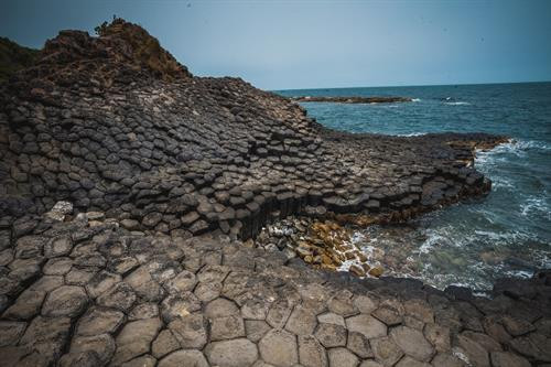 Những khối đá hình lăng trụ với màu đen huyền bí xếp sát nhau nhìn như một tổ ong khổng lồ. Ảnh: Trọng Đạt - TTXVN Những khối đá hình lăng trụ với màu đen huyền bí xếp sát nhau nhìn như một tổ ong khổng lồ. Ảnh: Trọng Đạt - TTXVN