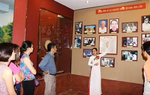 Du khách nghe giới thiệu về cuộc đời và bản Dạ cổ hoài lang của cố Nhạc sĩ Cao Văn Lầu. Ảnh: Đ.H