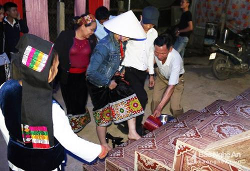 Rước dâu lúc nửa đêm là tục lệ lâu đời của người Thái ở huyện Con Cuông (Nghệ An). Dẫu vậy thì ngày nay, tục lệ đã mang sắc màu mới. Đó là vẫn rước dâu trong đêm nhưng đã có xe hoa, xe máy, sự kiện trọng đại này ở những bản người Thái vùng cao. Trong ảnh là lễ rước dâu lúc nửa đêm của một đám cưới ở bản Đình, xã Chi Khê (Con Cuông). Ảnh: Hữu Vi Như lệ thường, ông bà mối là nhân vật quan trọng của lễ cưới. Họ đóng vai trò là "trọng tài" trong những cuộc thương thuyết xin dâu ở nhà gái. Về sau, ông bà mối được đôi vợ chồng trẻ xem như cha mẹ đẻ. Trong ảnh là người phụ nữ tên An - người được gia đình chú rể chọn làm bà mối cho đám cưới ở bản Đình, xã Chi Khê (Con Cuông). Ảnh: Hữu Vi Khi nghe tiếng chiêng vang lên từ ngoài bản báo hiệu cô dâu đã ở rất gần, đoàn nhà trai thắp đuốc ra rước vào nhà. Ảnh: Hữu Vi Khi xe hoa tắt máy, mở cửa, bà mối đã bật ứng dụng đèn pin trên điện thoại để chàng rể và nàng dâu nhìn rõ đường và dắt nhau vào nhà. Ảnh: Hữu Vi Nắm tay con dâu, dẫn vào buồng cưới là cử chỉ thân thương của mẹ chồng trong đêm đón rước. Ảnh: Hữu Vi Trong một đám cưới khác ở cùng bản, cô dâu trước khi bước lên cầu thang được gia đình nhà chồng làm nghi thức "rửa chân". Đây cũng là tục lệ truyền đời của cộng đồng người Thái ở huyện Con Cuông. Ảnh: Hữu Vi Đôi tân lang, tân nương cùng một cặp bạn trẻ ăn chung bữa cơm trước khi động phòng. Ảnh: Hữu Vi Rước dâu lúc nửa đêm là tục lệ lâu đời của người Thái ở huyện Con Cuông (Nghệ An). Dẫu vậy thì ngày nay, tục lệ đã mang sắc màu mới. Đó là vẫn rước dâu trong đêm nhưng đã có xe hoa, xe máy, sự kiện trọng đại này ở những bản người Thái vùng cao. Trong ảnh là lễ rước dâu lúc nửa đêm của một đám cưới ở bản Đình, xã Chi Khê (Con Cuông). Ảnh: Hữu Vi Như lệ thường, ông bà mối là nhân vật quan trọng của lễ cưới. Họ đóng vai trò là "trọng tài" trong những cuộc thương thuyết xin dâu ở nhà gái. Về sau, ông bà mối được đôi vợ chồng trẻ xem như cha mẹ đẻ. Trong ảnh là người phụ nữ tên An - người được gia đình chú rể chọn làm bà mối cho đám cưới ở bản Đình, xã Chi Khê (Con Cuông). Ảnh: Hữu Vi Khi nghe tiếng chiêng vang lên từ ngoài bản báo hiệu cô dâu đã ở rất gần, đoàn nhà trai thắp đuốc ra rước vào nhà. Ảnh: Hữu Vi Khi xe hoa tắt máy, mở cửa, bà mối đã bật ứng dụng đèn pin trên điện thoại để chàng rể và nàng dâu nhìn rõ đường và dắt nhau vào nhà. Ảnh: Hữu Vi Nắm tay con dâu, dẫn vào buồng cưới là cử chỉ thân thương của mẹ chồng trong đêm đón rước. Ảnh: Hữu Vi Trong một đám cưới khác ở cùng bản, cô dâu trước khi bước lên cầu thang được gia đình nhà chồng làm nghi thức "rửa chân". Đây cũng là tục lệ truyền đời của cộng đồng người Thái ở huyện Con Cuông. Ảnh: Hữu Vi Đôi tân lang, tân nương cùng một cặp bạn trẻ ăn chung bữa cơm trước khi động phòng. Ảnh: Hữu Vi