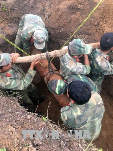 Lực lượng vũ trang huyện Đắk Mil di chuyển, hủy nổ quả bom MK82. Ảnh: TTXVN/phát