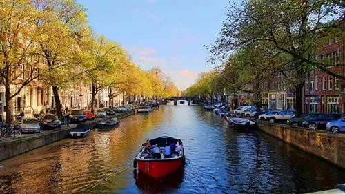 Thăm Thủ đô Amsterdam với xe đạp và hệ thống kênh đào nổi tiếng: Hệ thống kênh đào của Hà Lan vô cùng ấn tượng đã được UNESCO công nhận là di sản thế giới. Di chuyển bằng thuyền trên những con kênh là cách dễ dàng để có thể vòng quanh thành phố. Công trình kênh đào được xây dựng để rút cạn bãi lầy nhằm mở rộng Amsterdam. 2 bên kênh đào ở Amsterdam san sát những ngôi nhà xinh xắn, được gọi là Dancing House. Vùng đất ở đây rất lầy dẫn đến hiện tượng nghiêng của các ngôi nhà đầy màu sắc. Không phải những chiếc ôtô đắt tiền, xe đạp mới là phương tiện chính yếu được khuyến khích sử dụng tại Hà Lan. Bạn có thể bắt gặp xe đạp ở mọi nơi, mọi ngóc ngách khi có gần 60% dân số sử dụng xe đạp là phương tiện di chuyển hàng ngày thay thế ôtô. Hà Lan hướng đến một cuộc sống giảm thiểu tác nhân gây hại môi trường và ô nhiễm tiếng ồn. Tàu điện leng keng cũng là một phương tiện phổ biến ở Amsterdam. Đạp xe hít thở bầu không khí trong lành tràn ngập cây xanh: Một trong những nhiệm vụ trọng tâm mà chính phủ Hà Lan đề ra là bảo vệ thiên nhiên và động vật hoang dã. Các công viên quốc gia với số lượng cây xanh khổng lồ chiếm diện tích khá lớn, trải dài trên khắp đất nước Hà Lan, giao thoa khéo léo với các tuyến đường huyết mạch. Ngủ qua đêm trên những con thuyền dọc bờ kênh Amsterdam: Tàu thuyền là phương tiện lưu trú phổ biến ở Hà Lan. Đến đất nước này, thay vì lưu trú tại các khách sạn thông thường trong thành phố, bạn hãy thử chọn “boat hotel” dọc các con kênh để có thêm trải nghiệm mới lạ. Bình minh trên các con thuyền nhìn ra mặt nước phẳng lặng mang lại cảm giác vô cùng thú vị và thư giãn. Ngây ngất trước vườn hoa lớn nhất thế giới Keukenhof: Cách thủ đô Amsterdam 30 km về hướng tây nam, KeuKenhof trải dài trên khuôn đất rộng 30 ha là nơi hàng nghìn loài hoa trong đó có loài tulip - biểu tượng của đất nước Hà Lan xinh đẹp ngự trị. Đến làng Kinderdijk, bạn nên thuê xe đạp để tham quan, dạo quanh những con đường ngoằn nghèo, uốn khúc, tận hưởng khung cảnh bình yên, mộc mạc này. Ngắm nhìn làng cối xay gió lâu đời nhất Hà Lan: Khách du lịch thông thường hay chọn đến làng Zaanse Schans bởi gần thủ đô hơn, những chiếc cối xay gió lại có màu sắc bắt mắt. Nhưng nếu muốn khám phá những gì nguyên sơ và lâu đời nhất, làng Kinderdijk nên là sự lựa chọn hàng đầu bởi ở đây còn bảo tồn toàn vẹn 19 cối xay gió lâu đời nhất của Hà Lan. Ngôi làng này đã được UNESCO công nhận là di sản văn hóa thế giới vào năm 1997. Những chiếc cối xay gió đầu tiên ra đời xuất phát từ nguyên do đất nước Hà Lan nằm dưới mực nước biển đến 30%. Chúng làm nhiệm vụ điều chuyển dòng nước, là những máy bơm dựa vào sức lực của tự nhiên giúp đất nước Hà Lan không bị nhấn chìm dưới mực nước biển. Chiếc thuyền nhẹ nhàng lướt đi dọc theo kênh rạch nhỏ, qua những ngôi nhà lợp mái tranh lâu đời vẫn tồn tại từ thế kỷ 18, mang lại cho bạn cảm giác không thể nào quên. Ở Giethoorn, âm thanh to nhất bạn có thể nghe là tiếng quàn quạc của bầy vịt đang bơi dưới mặt nước, hoặc tiếng kêu của các loài chim khác thi thoảng vỗ cánh bay qua đỉnh đầu. Giethoorn thuộc tỉnh Overijssel, Hà Lan. Cái tên Giethoorn (sừng dê) xuất phát từ khám phá của những cư dân đầu tiên đến từ Địa Trung Hải. Họ đã tìm thấy tại đây hàng trăm chiếc sừng dê, hậu quả của trận lũ lịch sử vào thế kỷ thứ 10. Đến đây, bạn có thể thuê thuyền của dân địa phương với giá 20 euro/giờ. Thông thường, trong khoảng 2-3 giờ, bạn có thể hoàn tất hành trình khám phá ngôi làng nhỏ này. Ghé thăm ngôi làng cổ tích đẹp nhất thế giới Giethoorn: Ở Giethoorn, khói bụi và tiếng còi của xe cộ không tồn tại. Khi đặt chân đến đây, mọi người phải để lại xe hơi bên ngoài làng, thuê thuyền mà người dân gọi là “Whisper boat” (Thuyền thì thầm) có động cơ không gây tiếng ồn để “tiếp cận” ngôi làng,hoặc có thể đi bộ qua hơn 176 cây cầu vòm bằng gỗ. Nhưng nhiều ngôi nhà đến nay vẫn không thể tới được bằng đường bộ. Ngay cả những người đưa thư báo cũng phải giao thư từ bằng cách đi thuyền. Đến thăm Anne Frank House với những trải nghiệm xúc động: Anne Frank House là nơi tưởng niệm cô gái nhỏ là nạn nhân của nạn diệt chủng người Do Thái thời Hitler và là tác giả của cuốn Nhật ký Anne Frank, được khai bút vào năm 1942 khi cô mới 13 tuổi. Tham quan Anne Frank House ở Amsterdam là một trải nghiệm xúc động cho mọi người. Khi đến đây, bạn phải xếp hàng khá lâu nếu không đặt vé online ở mục "skip the line" (không phải xếp hàng). Khi vào bên trong, bạn không được phép chụp hình. Bức tượng Anne Frank trước nhà thờ ngay cạnh nhà. Dù toàn bộ trải nghiệm khi thăm nhà Anne Frank rất đau buồn, đó là một dấu ấn của lịch sử, ghi lại sự anh hùng và khắc nghiệt của Thế chiến. Anne Frank House và cuốn nhật ký kinh điển là một lời nhắc nhở chúng ta hãy sống mỗi ngày một cách trọn vẹn nhất, để tìm thấy niềm vui trong những điều nhỏ nhặt, và hãy yêu thương người khác bằng một trái tim rộng mở. Hà Lan quả thật rất đặc biệt. Giữa cuộc sống hiện đại, bạn có thể tìm thấy được sự bình yên, cảm giác an toàn và thư thả, khác biệt với bất cứ nơi nào xô bồ và hiện đại mà bạn đã và sẽ đi qua. Đất nước đáng sống bậc nhất thế giới này nên có trong cuốn sổ du lịch của những tín đồ đam mê khám phá trải nghiệm. Thăm Thủ đô Amsterdam với xe đạp và hệ thống kênh đào nổi tiếng: Hệ thống kênh đào của Hà Lan vô cùng ấn tượng đã được UNESCO công nhận là di sản thế giới. Di chuyển bằng thuyền trên những con kênh là cách dễ dàng để có thể vòng quanh thành phố. Công trình kênh đào được xây dựng để rút cạn bãi lầy nhằm mở rộng Amsterdam. 2 bên kênh đào ở Amsterdam san sát những ngôi nhà xinh xắn, được gọi là Dancing House. Vùng đất ở đây rất lầy dẫn đến hiện tượng nghiêng của các ngôi nhà đầy màu sắc. Không phải những chiếc ôtô đắt tiền, xe đạp mới là phương tiện chính yếu được khuyến khích sử dụng tại Hà Lan. Bạn có thể bắt gặp xe đạp ở mọi nơi, mọi ngóc ngách khi có gần 60% dân số sử dụng xe đạp là phương tiện di chuyển hàng ngày thay thế ôtô. Hà Lan hướng đến một cuộc sống giảm thiểu tác nhân gây hại môi trường và ô nhiễm tiếng ồn. Tàu điện leng keng cũng là một phương tiện phổ biến ở Amsterdam. Đạp xe hít thở bầu không khí trong lành tràn ngập cây xanh: Một trong những nhiệm vụ trọng tâm mà chính phủ Hà Lan đề ra là bảo vệ thiên nhiên và động vật hoang dã. Các công viên quốc gia với số lượng cây xanh khổng lồ chiếm diện tích khá lớn, trải dài trên khắp đất nước Hà Lan, giao thoa khéo léo với các tuyến đường huyết mạch. Ngủ qua đêm trên những con thuyền dọc bờ kênh Amsterdam: Tàu thuyền là phương tiện lưu trú phổ biến ở Hà Lan. Đến đất nước này, thay vì lưu trú tại các khách sạn thông thường trong thành phố, bạn hãy thử chọn “boat hotel” dọc các con kênh để có thêm trải nghiệm mới lạ. Bình minh trên các con thuyền nhìn ra mặt nước phẳng lặng mang lại cảm giác vô cùng thú vị và thư giãn. Ngây ngất trước vườn hoa lớn nhất thế giới Keukenhof: Cách thủ đô Amsterdam 30 km về hướng tây nam, KeuKenhof trải dài trên khuôn đất rộng 30 ha là nơi hàng nghìn loài hoa trong đó có loài tulip - biểu tượng của đất nước Hà Lan xinh đẹp ngự trị. Đến làng Kinderdijk, bạn nên thuê xe đạp để tham quan, dạo quanh những con đường ngoằn nghèo, uốn khúc, tận hưởng khung cảnh bình yên, mộc mạc này. Ngắm nhìn làng cối xay gió lâu đời nhất Hà Lan: Khách du lịch thông thường hay chọn đến làng Zaanse Schans bởi gần thủ đô hơn, những chiếc cối xay gió lại có màu sắc bắt mắt. Nhưng nếu muốn khám phá những gì nguyên sơ và lâu đời nhất, làng Kinderdijk nên là sự lựa chọn hàng đầu bởi ở đây còn bảo tồn toàn vẹn 19 cối xay gió lâu đời nhất của Hà Lan. Ngôi làng này đã được UNESCO công nhận là di sản văn hóa thế giới vào năm 1997. Những chiếc cối xay gió đầu tiên ra đời xuất phát từ nguyên do đất nước Hà Lan nằm dưới mực nước biển đến 30%. Chúng làm nhiệm vụ điều chuyển dòng nước, là những máy bơm dựa vào sức lực của tự nhiên giúp đất nước Hà Lan không bị nhấn chìm dưới mực nước biển. Chiếc thuyền nhẹ nhàng lướt đi dọc theo kênh rạch nhỏ, qua những ngôi nhà lợp mái tranh lâu đời vẫn tồn tại từ thế kỷ 18, mang lại cho bạn cảm giác không thể nào quên. Ở Giethoorn, âm thanh to nhất bạn có thể nghe là tiếng quàn quạc của bầy vịt đang bơi dưới mặt nước, hoặc tiếng kêu của các loài chim khác thi thoảng vỗ cánh bay qua đỉnh đầu. Giethoorn thuộc tỉnh Overijssel, Hà Lan. Cái tên Giethoorn (sừng dê) xuất phát từ khám phá của những cư dân đầu tiên đến từ Địa Trung Hải. Họ đã tìm thấy tại đây hàng trăm chiếc sừng dê, hậu quả của trận lũ lịch sử vào thế kỷ thứ 10. Đến đây, bạn có thể thuê thuyền của dân địa phương với giá 20 euro/giờ. Thông thường, trong khoảng 2-3 giờ, bạn có thể hoàn tất hành trình khám phá ngôi làng nhỏ này. Ghé thăm ngôi làng cổ tích đẹp nhất thế giới Giethoorn: Ở Giethoorn, khói bụi và tiếng còi của xe cộ không tồn tại. Khi đặt chân đến đây, mọi người phải để lại xe hơi bên ngoài làng, thuê thuyền mà người dân gọi là “Whisper boat” (Thuyền thì thầm) có động cơ không gây tiếng ồn để “tiếp cận” ngôi làng,hoặc có thể đi bộ qua hơn 176 cây cầu vòm bằng gỗ. Nhưng nhiều ngôi nhà đến nay vẫn không thể tới được bằng đường bộ. Ngay cả những người đưa thư báo cũng phải giao thư từ bằng cách đi thuyền. Đến thăm Anne Frank House với những trải nghiệm xúc động: Anne Frank House là nơi tưởng niệm cô gái nhỏ là nạn nhân của nạn diệt chủng người Do Thái thời Hitler và là tác giả của cuốn Nhật ký Anne Frank, được khai bút vào năm 1942 khi cô mới 13 tuổi. Tham quan Anne Frank House ở Amsterdam là một trải nghiệm xúc động cho mọi người. Khi đến đây, bạn phải xếp hàng khá lâu nếu không đặt vé online ở mục "skip the line" (không phải xếp hàng). Khi vào bên trong, bạn không được phép chụp hình. Bức tượng Anne Frank trước nhà thờ ngay cạnh nhà. Dù toàn bộ trải nghiệm khi thăm nhà Anne Frank rất đau buồn, đó là một dấu ấn của lịch sử, ghi lại sự anh hùng và khắc nghiệt của Thế chiến. Anne Frank House và cuốn nhật ký kinh điển là một lời nhắc nhở chúng ta hãy sống mỗi ngày một cách trọn vẹn nhất, để tìm thấy niềm vui trong những điều nhỏ nhặt, và hãy yêu thương người khác bằng một trái tim rộng mở. Hà Lan quả thật rất đặc biệt. Giữa cuộc sống hiện đại, bạn có thể tìm thấy được sự bình yên, cảm giác an toàn và thư thả, khác biệt với bất cứ nơi nào xô bồ và hiện đại mà bạn đã và sẽ đi qua. Đất nước đáng sống bậc nhất thế giới này nên có trong cuốn sổ du lịch của những tín đồ đam mê khám phá trải nghiệm.