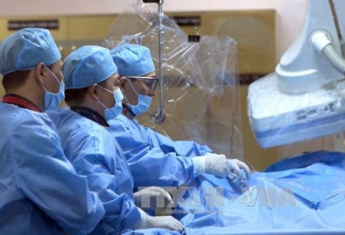 Ê kip phẫu thuật can thiệp tim mạch cấp cứu bệnh nhân. Ảnh: TTXVN phát Ê kip phẫu thuật can thiệp tim mạch cấp cứu bệnh nhân. Ảnh: TTXVN phát