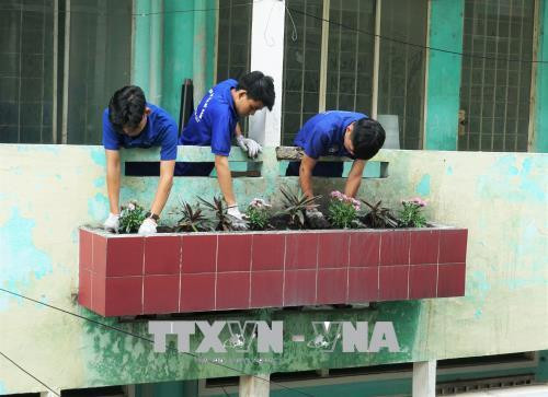 Thanh niên tình nguyện tham gia dọn dẹp và trồng cây, hoa tại chung cư Nguyễn Văn Lượng 3 (quận Gò Vấp), hưởng ứng nội dung xây dựng “Chung cư văn minh, sạch đẹp, an toàn”. Ảnh: Thu Hoài – TTXVN