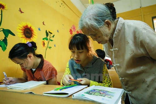 Khi thì bà kiểm tra tính toán của một em nhỏ. (Ảnh: Minh Sơn/Vietnam+) Khi thì bà kiểm tra tính toán của một em nhỏ. (Ảnh: Minh Sơn/Vietnam+)