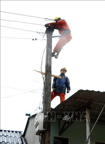 Cán bộ điện lực huyện Bảo Yên khắc phục sự cố mất điện sau mưa lũ. Ảnh: Quốc Khánh – TTXVN Cán bộ điện lực huyện Bảo Yên khắc phục sự cố mất điện sau mưa lũ. Ảnh: Quốc Khánh – TTXVN