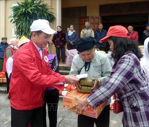 Đội tình nguyện viên Chữ thập đỏ Tân Hòa trao bánh chưng và quà tết cho người nghèo và người có hoàn cảnh khó khăn. Ảnh: Quang Đán – TTXVN Đội tình nguyện viên Chữ thập đỏ Tân Hòa trao bánh chưng và quà tết cho người nghèo và người có hoàn cảnh khó khăn. Ảnh: Quang Đán – TTXVN