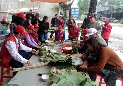 Các thành viên trong Đội tình nguyện viên Chữ thập đỏ Tân Hòa tập trung gói bánh chưng tặng cho người nghèo đón Tết. Ảnh: Quang Đán – TTXVN Các thành viên trong Đội tình nguyện viên Chữ thập đỏ Tân Hòa tập trung gói bánh chưng tặng cho người nghèo đón Tết. Ảnh: Quang Đán – TTXVN