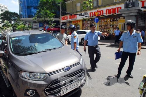Lực lượng chức năng xử lý các ô tô đậu lấn chiếm lề đường Nguyễn Thái Bình. Ảnh: Mạnh Linh - TTXVN Lực lượng chức năng xử lý các ô tô đậu lấn chiếm lề đường Nguyễn Thái Bình. Ảnh: Mạnh Linh - TTXVN