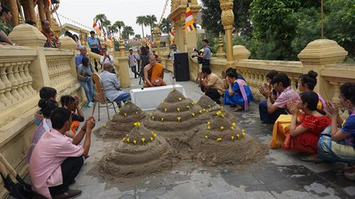 Mọi người cùng nhau đắp núi cát để mong muốn tích phúc, an lành cho năm mới. Ảnh: Nam Sương