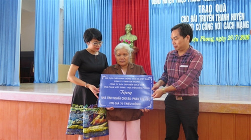 Các đại biểu trao tặng tượng trưng nhà tình nghĩa cho bà Phan Thị Hiển. Ảnh: Trần Tĩnh-TTXVN