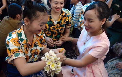 Các bạn lưu học sinh Lào buộc chỉ vào cổ tay cầu may mắn cho các vị khách.
