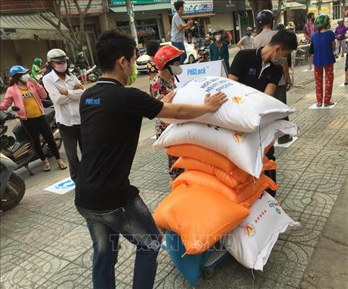 Chiều 7/4, một số mạnh thường quân bắt đầu quyên góp ủng hộ gạo miễn phí cho người dân nghèo. Ảnh: Hứa Chung - TTXVN