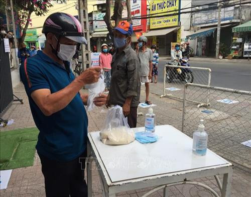 Ngoài phát gạo miễn phí, còn có khu vực rửa tay sát khuẩn và phát khẩu trang miễn phí cho người dân có nhu cầu. Ảnh: Hứa Chung - TTXVN