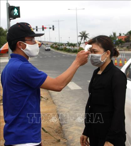 Các đoàn viên thanh niên đo thân nhiệt người dân tại chốt kiểm soát dịch trên tuyến đường ven biển tỉnh Quảng Nam. Ảnh: Trịnh Bang Nhiệm - TTXVN Các đoàn viên thanh niên đo thân nhiệt người dân tại chốt kiểm soát dịch trên tuyến đường ven biển tỉnh Quảng Nam. Ảnh: Trịnh Bang Nhiệm - TTXVN