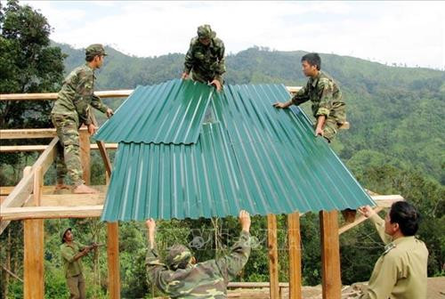 Cán bộ, chiến sỹ Bộ đội Biên phòng Lai Châu giúp dân dựng nhà, lập bản để định cư, ổn định cuộc sống. Ảnh: Công Tuyên-TTXVN