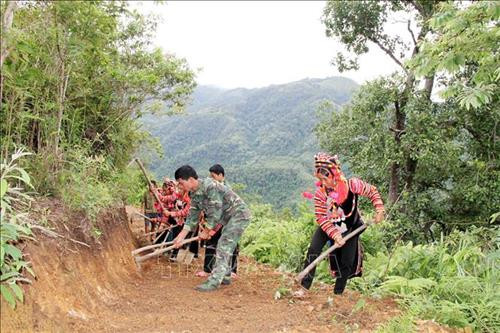 Cán bộ, chiến sỹ Bộ đội Biên phòng Lai Châu cùng bà con nhân dân mở đường vào bản. Ảnh: Công Tuyên-TTXVN
