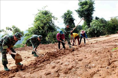Cán bộ, chiến sỹ Bộ đội Biên phòng Lai Châu cùng bà con nhân dân mở đường vào bản. Ảnh: Công Tuyên-TTXVN
