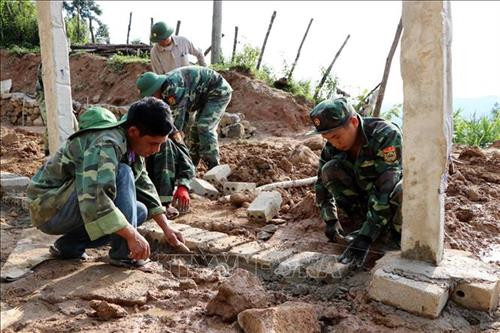 Cán bộ, chiến sỹ Bộ đội Biên phòng Lai Châu giúp dân dựng nhà, lập bản để định cư, ổn định cuộc sống. Ảnh: Công Tuyên-TTXVN