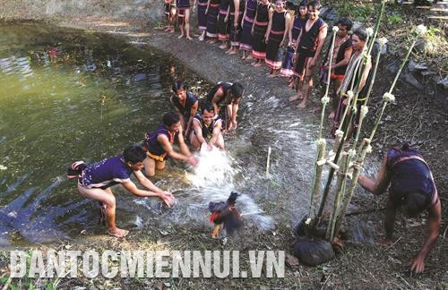 Dân làng tiến hành nghi lễ dùng tay té nước vào con gà và chàng thanh niên to khoẻ. Ảnh: Như Nguyễn Dân làng tiến hành nghi lễ dùng tay té nước vào con gà và chàng thanh niên to khoẻ. Ảnh: Như Nguyễn