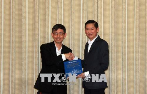 Ông Trần Vĩnh Tuyến, Phó Chủ tịch Ủy ban nhân dân Thành phố Hồ Chí Minh (phải) tặng sách giới thiệu về Thành phố Hồ Chí Minh cho ông Peter Ong, Chủ tịch Cục Phát triển Doanh nghiệp Singapore, Cố vấn Kinh tế cấp cao của Bộ Công thương Singapore. Ảnh: Xuân Khu-TTXVN