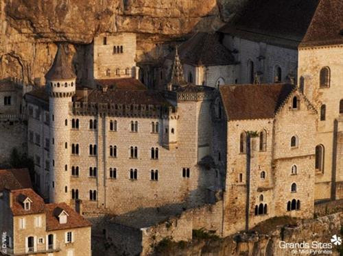 Ngôi làng cổ Rocamadour được xây dựng trên vách núi ở vùng Occitanie, miền tây nam Pháp. Từ thời Trung cổ, ngôi làng đã thu hút những người hành hương từ khắp châu Âu tới đây tham quan các công trình lịch sử và nhà thờ Đức Mẹ Maria. Thánh St Amator đã sống và qua đời tại ngôi làng Rocamadour ngay sau khi ông rời khỏi Jerusalem. Truyền thuyết kể rằng sau khi thi thể thánh St Amator được phát hiện, một số phép màu đã xảy ra. Ngôi làng bắt đầu thu hút nhiều người hành hương và ủng hộ từ các nhà vua Pháp, giúp ngôi làng xây dựng các nơi thờ cúng. Một lý do khác khiến Rocamadour thu hút nhiều du khách là phong cảnh đẹp. Các công trình cổ được xây dựng trên vách núi nhìn xuống sông Alzou. Các tòa nhà trong làng có độ cao cách mặt đất phía dưới khoảng 120m. Trung tâm của ngôi làng là nhà thờ hành hương Notre Dame, được cải tạo lại từ công trình gốc được xây dựng từ năm 1479. Ngoài ra, Rocamadour còn có nhiều công trình cổ kính khác được xây dựng từ thời Trung cổ. Du khách tham quan dọc một con đường dốc tại ngôi làng cổ Rocamadour. Những ngôi nhà được xây dựng trên vách đá dựng đứng. Ngôi làng cổ Rocamadour được xây dựng trên vách núi ở vùng Occitanie, miền tây nam Pháp. Từ thời Trung cổ, ngôi làng đã thu hút những người hành hương từ khắp châu Âu tới đây tham quan các công trình lịch sử và nhà thờ Đức Mẹ Maria. Thánh St Amator đã sống và qua đời tại ngôi làng Rocamadour ngay sau khi ông rời khỏi Jerusalem. Truyền thuyết kể rằng sau khi thi thể thánh St Amator được phát hiện, một số phép màu đã xảy ra. Ngôi làng bắt đầu thu hút nhiều người hành hương và ủng hộ từ các nhà vua Pháp, giúp ngôi làng xây dựng các nơi thờ cúng. Một lý do khác khiến Rocamadour thu hút nhiều du khách là phong cảnh đẹp. Các công trình cổ được xây dựng trên vách núi nhìn xuống sông Alzou. Các tòa nhà trong làng có độ cao cách mặt đất phía dưới khoảng 120m. Trung tâm của ngôi làng là nhà thờ hành hương Notre Dame, được cải tạo lại từ công trình gốc được xây dựng từ năm 1479. Ngoài ra, Rocamadour còn có nhiều công trình cổ kính khác được xây dựng từ thời Trung cổ. Du khách tham quan dọc một con đường dốc tại ngôi làng cổ Rocamadour. Những ngôi nhà được xây dựng trên vách đá dựng đứng.