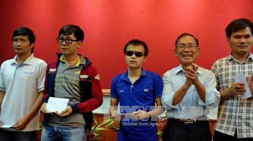 Ông Trương Hoàng, Chủ tịch Hội hữu nghị Việt Nam - Thái Lan Thành phố Hồ Chí Minh trao học bổng cho các VĐV khiếm thị thuộc CLB bóng đá khiếm thị Sài Gòn. Ảnh: Thế Anh-TTXVN