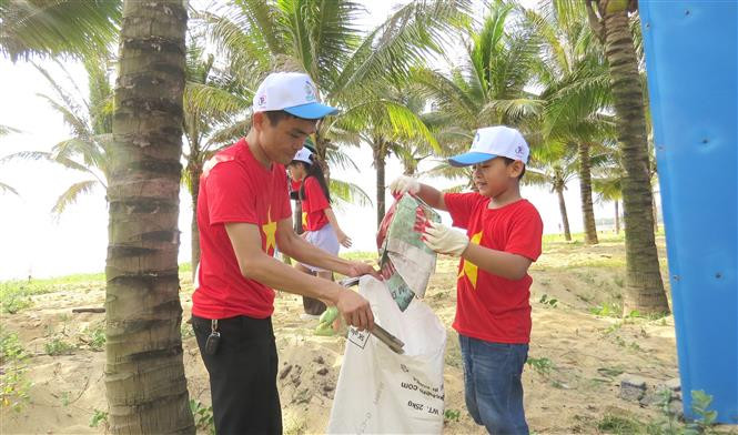 Chương trình còn thu hút đông các bạn nhỏ cùng tham gia hoạt động thu gom rác thải với các thành viên trong gia đình ngay sau lễ phát động. Ảnh: Võ Dung - TTXVN Tuổi trẻ Quảng Bình chung tay làm sạch môi trường, xây dựng nếp sống văn minh ảnh 3