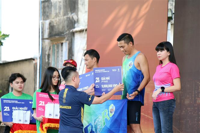 Ban Tổ chức trao giải cho các vận động viên Giải VnExpress Marathon Ho Chi Minh City Midnight 2023. Ảnh: Tiến Lực – TTXVN Sôi nổi giải chạy đêm Thành phố Hồ Chí Minh năm 2023 ảnh 4