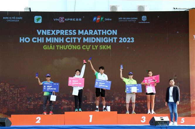Trao giải cho các vận động viên về nhất cự ly 5 km. Ảnh: Tiến Lực – TTXVN Sôi nổi giải chạy đêm Thành phố Hồ Chí Minh năm 2023 ảnh 5