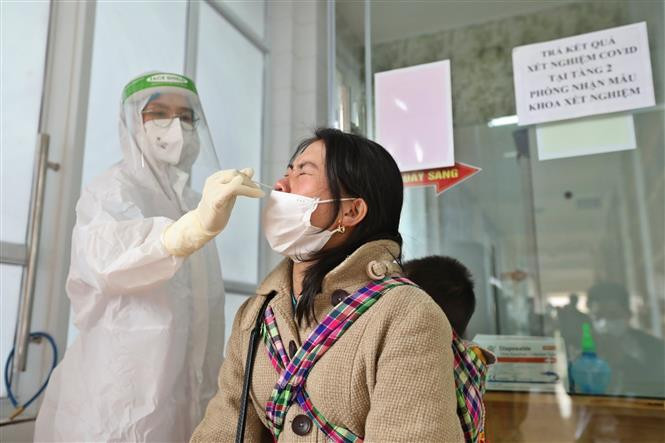 Nhân viên y tế lấy mẫu xét nghiệm COVID-19 cho người dân tại bệnh viện Đa khoa khu vực Nghĩa Lộ (Yên Bái). Ảnh: Minh Quyết – TTXVN Dịch COVID-19: Ngày 15/1, cả nước ghi nhận 16.378 ca mắc mới, có 12.695 ca trong cộng đồng ảnh 1