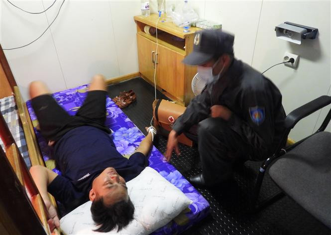 Bệnh nhân được cán bộ kiểm ngư trên tàu chăm sóc sức khỏe trước khi bàn giao cho Trung tâm Y tế thị trấn Trường Sa. Ảnh: TTXVN phát Khánh Hòa: Kịp thời đưa các bệnh nhân gặp nạn trên biển đi cấp cứu ảnh 2