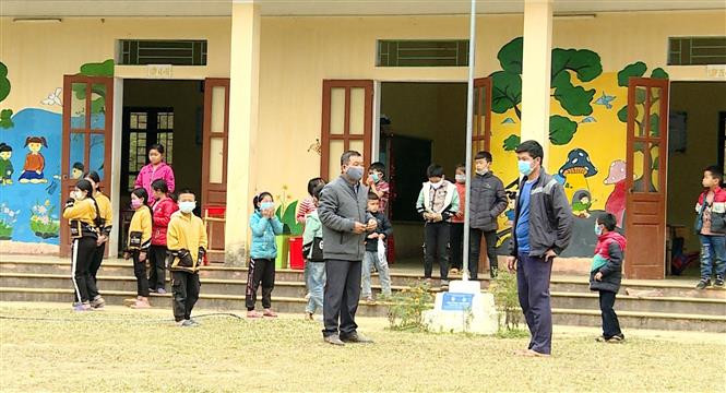 Anh Thèn Văn Hiển (bên phải) thăm hỏi tình hình học tập của các cháu học sinh tại điểm trường ở thôn Bản Giáng. Ảnh: Vũ Quang – TTXVN Bí thư chi bộ dân tộc Nùng giúp dân xóa bỏ hủ tục và phát triển kinh tế ảnh 2