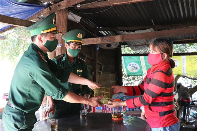 Cán bộ, chiến sĩ Đồn biên phòng Ea Rvê tặng bánh chưng cho nhân dân đón Tết tại xã biên giới Ea Rvê, huyện Ea Súp. Ảnh: Tuấn Anh – TTXVN Mang Xuân về vùng biên Đắk Lắk ảnh 3