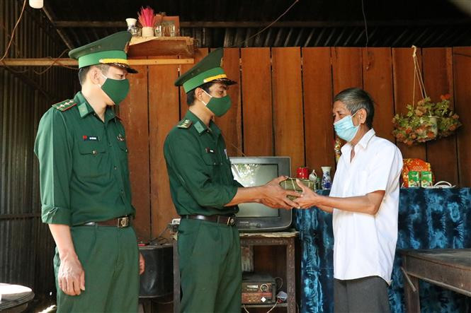 Cán bộ, chiến sĩ Đồn biên phòng Ea Rvê tặng bánh chưng cho nhân dân đón Tết tại xã biên giới Ea Rvê, huyện Ea Súp. Ảnh: Tuấn Anh – TTXVN Mang Xuân về vùng biên Đắk Lắk ảnh 5