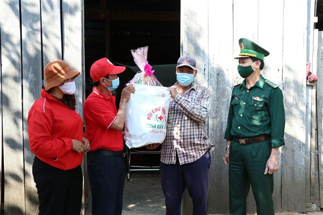 Bội đội biên phòng tỉnh Đắk Lắk phối hợp với Hội Chữ thập đỏ tỉnh tặng quà Tết cho hộ nghèo xã biên giới Ea Rvê, huyện Ea Súp. Ảnh: Tuấn Anh – TTXVN Mang Xuân về vùng biên Đắk Lắk ảnh 4