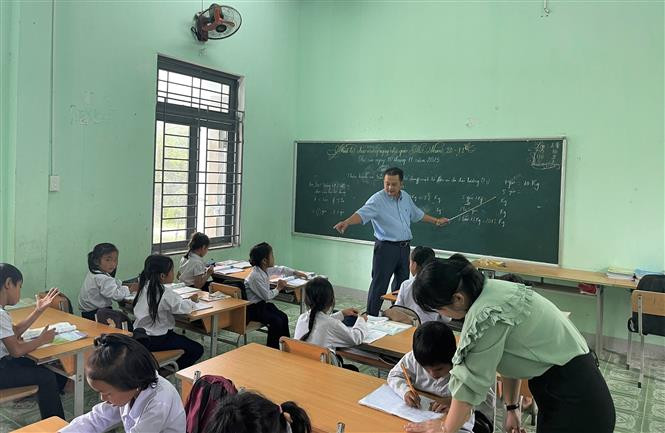 Thầy Nguyễn Thanh Tuấn và con gái Nguyễn Thị Ý Mỹ cùng giảng dạy, kèm cặp học sinh. Ảnh: Đinh Hương - TTXVN Ngày Nhà giáo Việt Nam 20/11: Cha và con thầy giáo cùng hành trình "gieo chữ" nơi vùng cao Trà Bồng ảnh 5