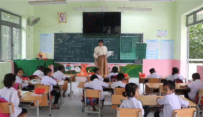 Cô giáo Nguyễn Thị Ý Mỹ giảng dạy lớp ghép 1-2. Ảnh: Đinh Hương - TTXVN Ngày Nhà giáo Việt Nam 20/11: Cha và con thầy giáo cùng hành trình "gieo chữ" nơi vùng cao Trà Bồng ảnh 3