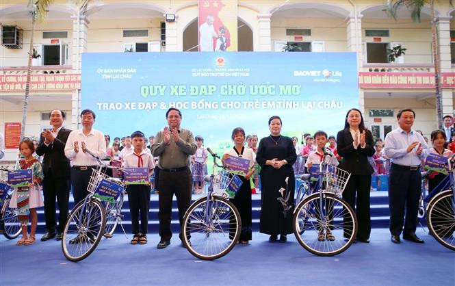 Thủ tướng Phạm Minh Chính cùng các đồng chí lãnh đạo tặng xe đạp của “Quỹ xe đạp chở ước mơ” cho học sinh có hoàn cảnh đặc biệt khó khăn của tỉnh Lai Châu. Ảnh: Quý Trung – TTXVN Thủ tướng Chính phủ Phạm Minh Chính thăm và làm việc tại Lai Châu ảnh 2