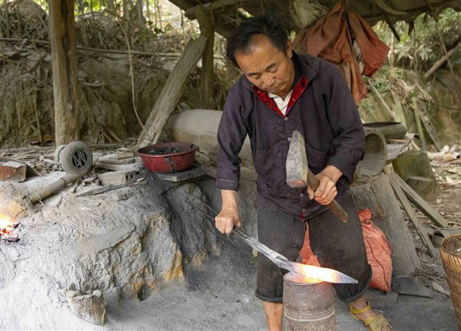Để làm ra một sản phẩm, người thợ rèn phải trải qua rất nhiều công đoạn, từ cắt sắt tạo hình, nung, đập, nhúng nước, rồi lại nung, đập, tới khi định hình được sản phẩm thì mài cho sắc, làm tay cầm. Ảnh: Xuân Tư – TTXVN Nghề rèn của người Mông ở Điện Biên được công nhận Di sản Văn hóa phi vật thể Quốc gia ảnh 3
