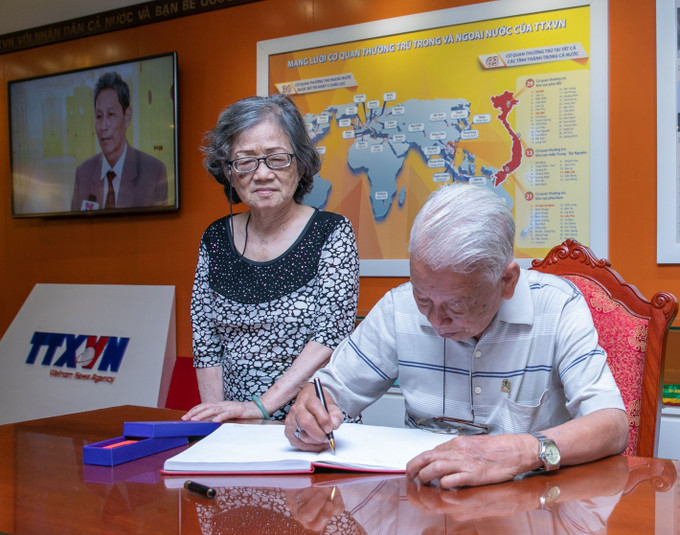 Nhà báo Phạm Văn Thính ghi lưu bút tại Phòng Truyền thống của TTXVN. Ảnh: Phạm Tuấn Anh - TTXVN Những tác phẩm nhiếp ảnh xuất sắc: Tài sản vô giá của nền Báo chí Cách mạng Việt Nam ảnh 21