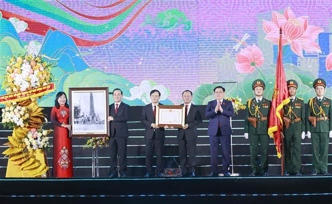 Chủ tịch Quốc hội Vương Đình Huệ trao Huân chương Độc lập hạng Nhì và tặng ảnh Bác Hồ, chúc mừng Đảng bộ, chính quyền và nhân dân thành phố Vinh. Ảnh: Doãn Tấn – TTXVN Chủ tịch Quốc hội Vương Đình Huệ dự Lễ Kỷ niệm 60 năm thành lập thành phố Vinh, 235 năm Phượng Hoàng Trung Đô ảnh 4