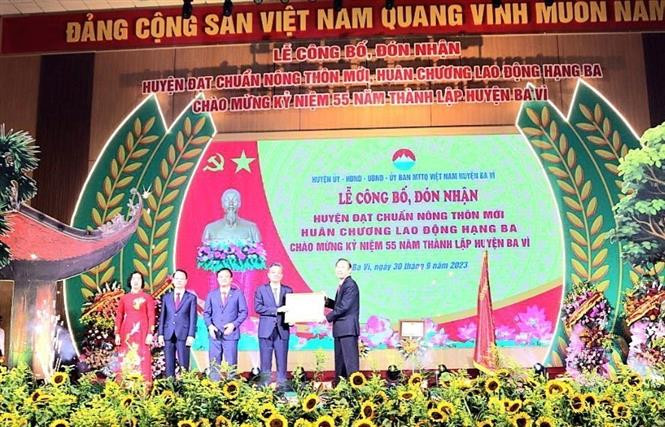 Thứ trưởng Bộ NN&PTNT Phùng Đức Tiến trao chứng nhận đạt chuẩn nông thôn mới cho lãnh đạo huyện Ba Vì. Ảnh: Mạnh Khánh - TTXVN Khai thác lợi thế tiềm năng Ba Vì để xây dựng nông thôn mới nâng cao ảnh 1