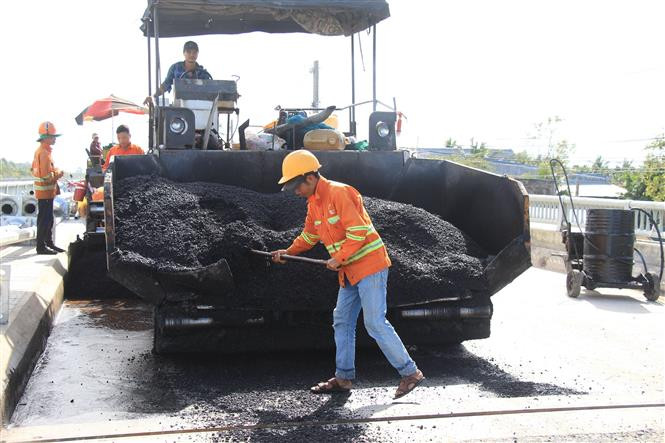 Công nhân thi công hạng mục mở rộng Đường 1 tháng 5 thuộc Tiểu dự án thành phố Vị Thanh. Ảnh: Hồng Thái - TTXVN Sức bật Hậu Giang ảnh 6