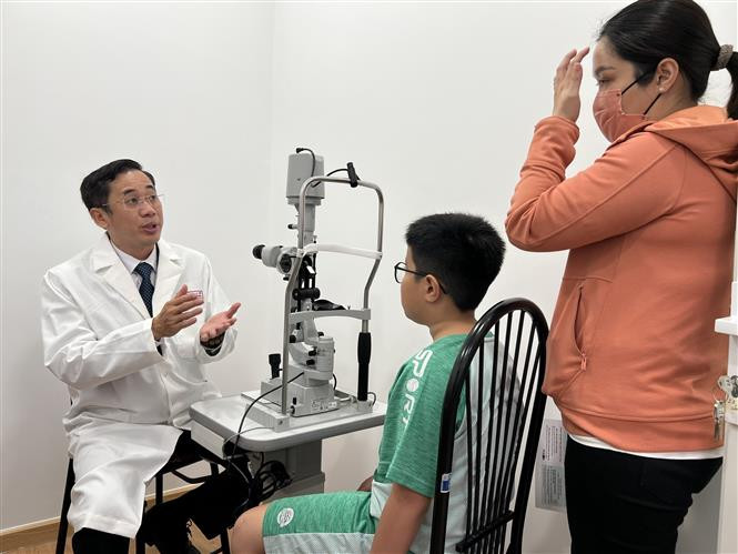 Bác sĩ khám và tư vấn cho một trường hợp trẻ mắc tật khúc xạ. Ảnh: Ánh Tuyết - TTXVN Ra mắt trung tâm tư vấn điều trị các bệnh lý võng mạc trẻ sinh non đầu tiên tại Đồng bằng sông Cửu Long ảnh 1