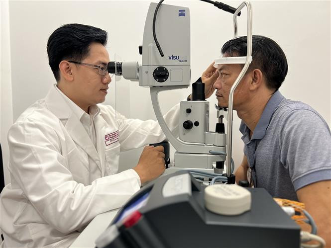 Các bác sĩ khám mắt cho bệnh nhân. Ảnh: Ánh Tuyết - TTXVN Ra mắt trung tâm tư vấn điều trị các bệnh lý võng mạc trẻ sinh non đầu tiên tại Đồng bằng sông Cửu Long ảnh 2