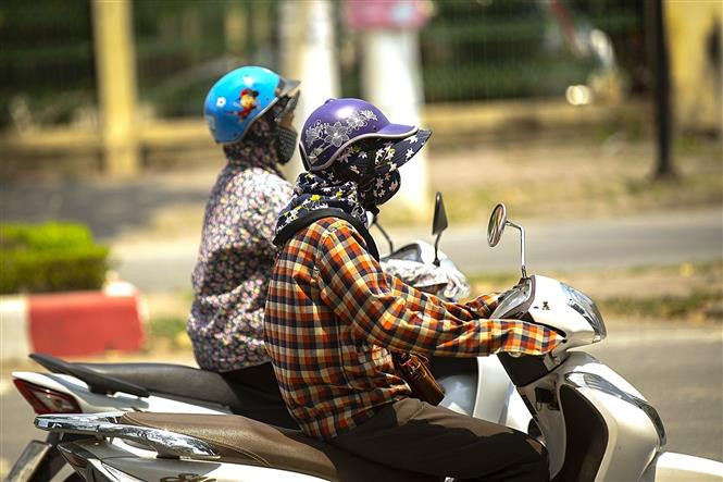 Người dân thành phố Hòa Bình, tỉnh Hòa Bình sử dụng trang phục chống nắng để bảo vệ sức khỏe khi bắt buộc phải ra ngoài trong thời tiết nắng nóng gay gắt. Ảnh: Trọng Đạt - TTXVN Chuyên gia hướng dẫn bảo vệ sức khỏe trong những ngày nắng nóng ảnh 3