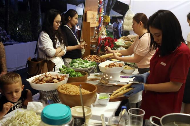 Du khách thưởng thức ẩm thực tại Phiên chợ. Ảnh: Trần Lê Lâm - TTXVN Đà Nẵng lần đầu tiên tổ chức Phiên chợ Giáng sinh ảnh 2